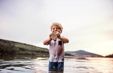 Ein kleiner Junge im Kleinkindalter spielt im Sommer draußen am Fluss. Raum kopieren. - HPIF19241