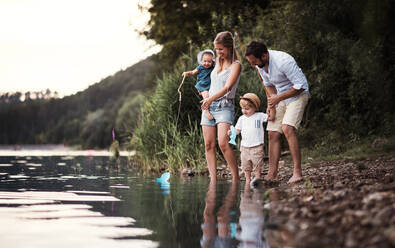 Eine junge Familie mit zwei Kleinkindern verbringt den Sommer im Freien am Fluss. - HPIF19248