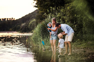 A young family with two toddler children spending time outdoors by the river in summer. - HPIF19274