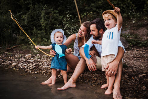 Eine junge Familie mit zwei Kleinkindern verbringt den Sommer im Freien am Fluss. - HPIF19277