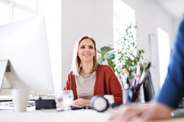 Portrait of a young businesswoman sitting at the desk. - HPIF19476