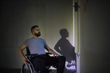 Hnadsome man in wheelchair looking out of the window. - HPIF19542