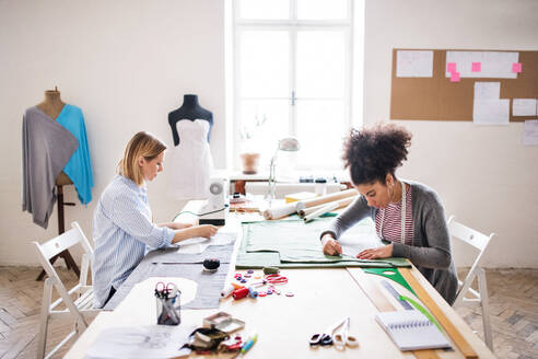 Junge kreative Frauen mit Nähmaschine bei der Arbeit in einem Atelier, Startup-Unternehmen. - HPIF19574