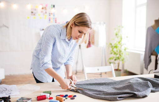 Schöne junge kreative Frau bei der Arbeit in einem Studio, Startup-Unternehmen. - HPIF19579