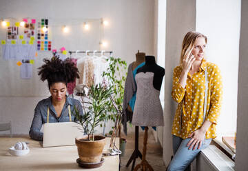 Junge kreative Frauen mit Laptop und Smartphone bei der Arbeit in einem Studio, Startup-Unternehmen. - HPIF19586