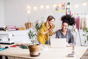 Junge kreative Frauen mit Laptop und Smartphone bei der Arbeit in einem Studio, Startup-Unternehmen. - HPIF19591