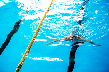 Älterer Mann beim Schwimmen in einem Hallenbad, aktiver Rentner beim Sport. - HPIF19667