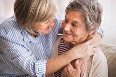 Zwei ältere Frauen, die sich zu Hause umarmen - das Konzept der Familie und der Generationen. - HPIF19731
