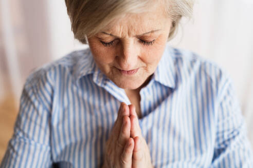 Eine ältere Frau betet zu Hause, Nahaufnahme. - HPIF19763