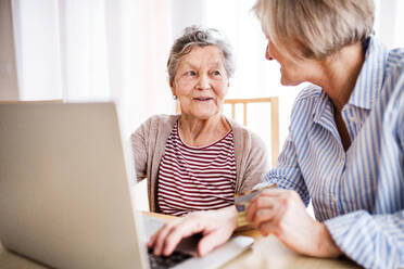 Unrecognizable senior woman with her mother with laptop at home. Family and generations concept. - HPIF19769