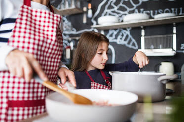 A small girl with unrecognizable grandmother at home, cooking. Family and generations concept. - HPIF19798