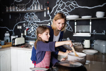 A small girl with her mother at home, cooking. Family and generations concept. - HPIF19807