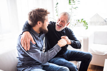 Hipster son with his senior father at home. Two generations indoors, having fun. - HPIF19860