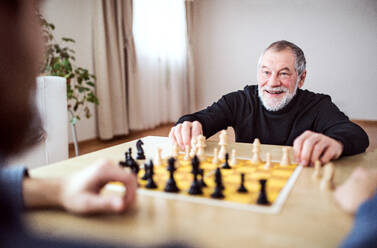 Hipster-Sohn und sein älterer Vater spielen zu Hause Schach - zwei Generationen in einem Haus. - HPIF19871