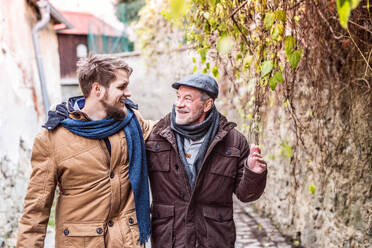 Senior father and his young son on a walk in town. - HPIF19893