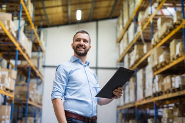 Portrait of a male warehouse worker or a supervisor holding notes. - HPIF20018