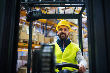 Man forklift driver working in a warehouse. - HPIF20027