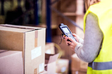 Unbekannte Lagerarbeiterin oder Aufsichtsperson mit Barcode-Scanner. Ein mobiler Handheld-PC mit Barcode-Scanner. - HPIF20054