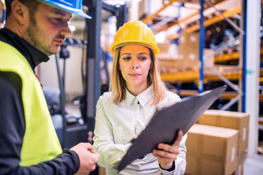 Junge Arbeiter arbeiten gemeinsam in einem Lagerhaus. - HPIF20075