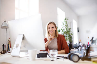 Businesswoman in wheelchair sitting at the desk, working. - HPIF20101