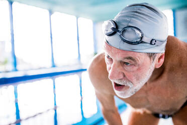 Älterer Mann in einem Hallenbad, aktiver Rentner beim Sport, Nahaufnahme. - HPIF20173