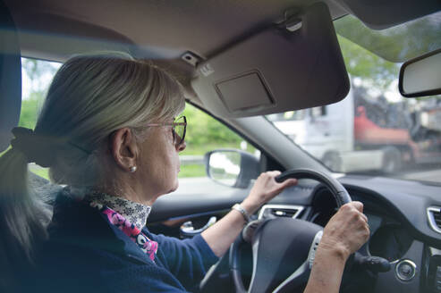 Senior woman wearing eyeglasses driving car - FRF01021