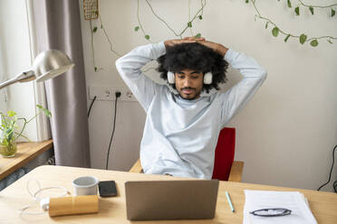 Freelancer with head in hands sitting at desk in home office - VPIF08156