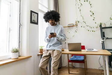 Young freelancer using mobile phone at home office - VPIF08163