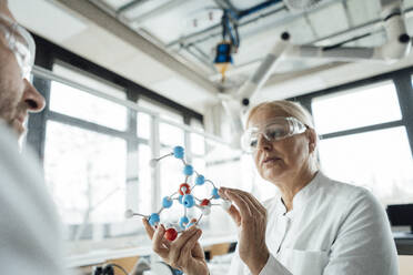 Scientist with colleague examining molecular structure in laboratory - JOSEF19544