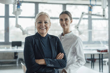 Happy businesswoman standing by colleague in laboratory - JOSEF19591