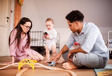 A young family with small toddler son indoors at home, playing. - HPIF20248