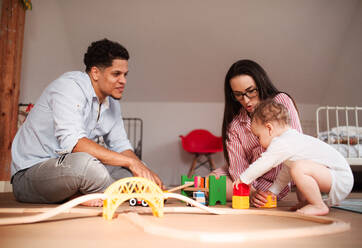 A young family with small toddler son indoors at home, playing. - HPIF20250