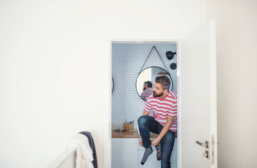Ein erwachsener Hipster-Mann, der sich zu Hause anzieht, kopiert den Raum. - HPIF20335