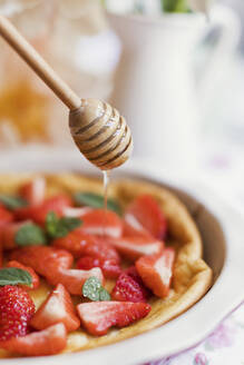 Honigguss auf holländischem Baby-Pfannkuchen mit Erdbeeren und Minze - ONAF00541