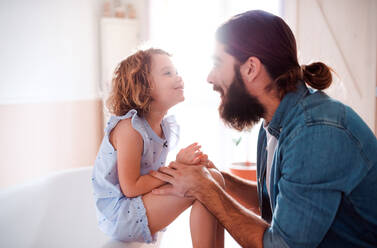 Ein niedliches kleines Mädchen mit jungem Vater zu Hause, im Gespräch. - HPIF20569
