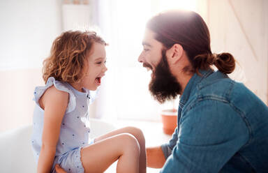A cute small girl with young father at home, talking. - HPIF20571