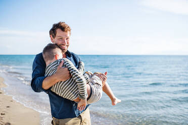 Vater mit kleinem Sohn bei einem Spaziergang am Strand, der Spaß macht. Kopierraum. - HPIF20656