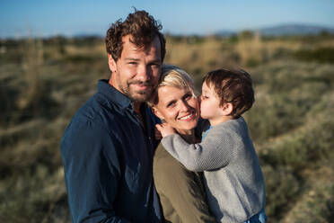 A portrait of young family with a small daughter standing outdoors in nature in Greece. - HPIF20680