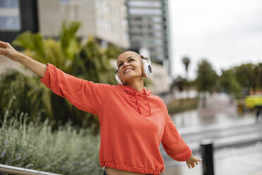 Carefree woman enjoying music and dancing - JCCMF10410