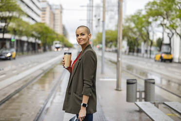 Woman waiting at tram station platform - JCCMF10416