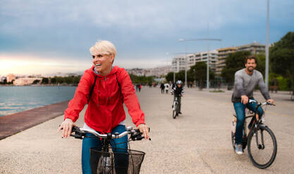 Young happy family riding bicycles outdoors on beach. - HPIF20848