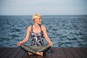 Frontansicht Porträt der jungen Sportlerin macht Yoga-Übung am Strand. kopieren Raum. - HPIF20910