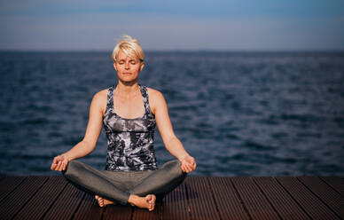 Frontansicht Porträt der jungen Sportlerin macht Yoga-Übung am Strand. kopieren Raum. - HPIF20911