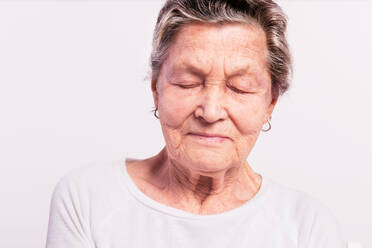Porträt einer älteren Frau mit geschlossenen Augen in einem Studio, Nahaufnahme. - HPIF21074