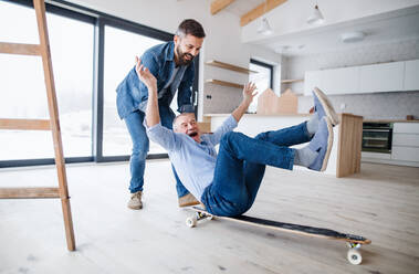 Two cheerful men having fun when furnishing new house, a new home concept. - HPIF21311