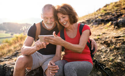 A senior tourist couple hikers in nature, taking selfie. - HPIF21397