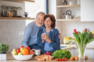 Ein Porträt eines verliebten, glücklichen älteren Paares, das zu Hause Kaffee trinkt. - HPIF21445
