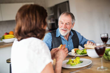 Ein verliebtes älteres Paar, das zu Hause zu Mittag isst und sich unterhält. - HPIF21486