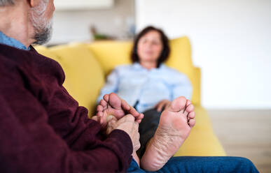 Ein verliebtes älteres Paar, das zu Hause auf dem Sofa sitzt und sich entspannt. - HPIF21490