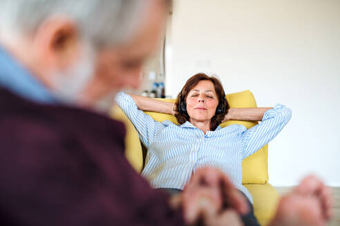 Ein verliebtes älteres Paar, das zu Hause auf dem Sofa sitzt und sich entspannt. - HPIF21491